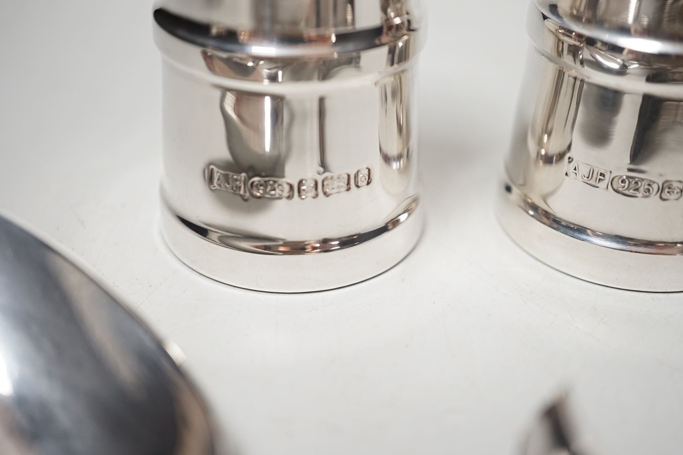 A modern pair silver mounted salt and pepper grinders, 10.6cm, a Georgian silver table spoon, A Victorian mother of pearl handled spoon and a damaged silver bangle.